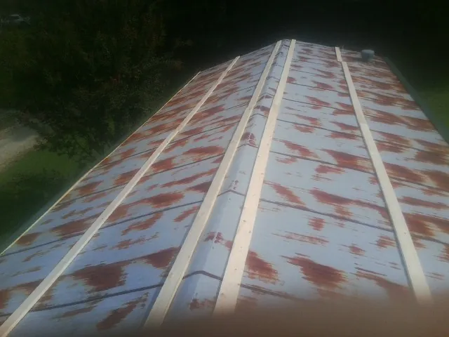 Rusted metal roof panels with new wood purlins before replacement — Storm Damage Roof Repair in Manvel by Roofing Brothers